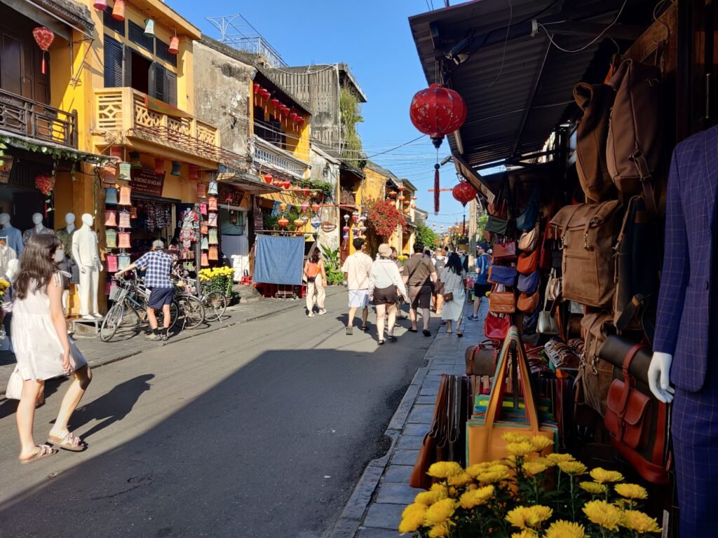 Photo des commerces, des tailleurs et leurs bâtiments jaunes dans une rue historiques de la vieille ville d'Hội An, au Vietnam